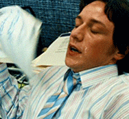 Celebrity gif. James McAvoy leans back in an office chair, face glistening with sweat. He breathes in and out heavily, fanning himself with papers.