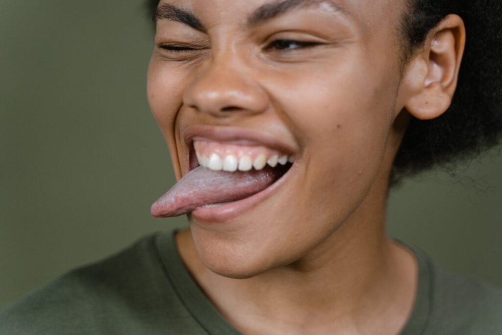 Close-up of a cheerful woman with her tongue out, winking playfully.