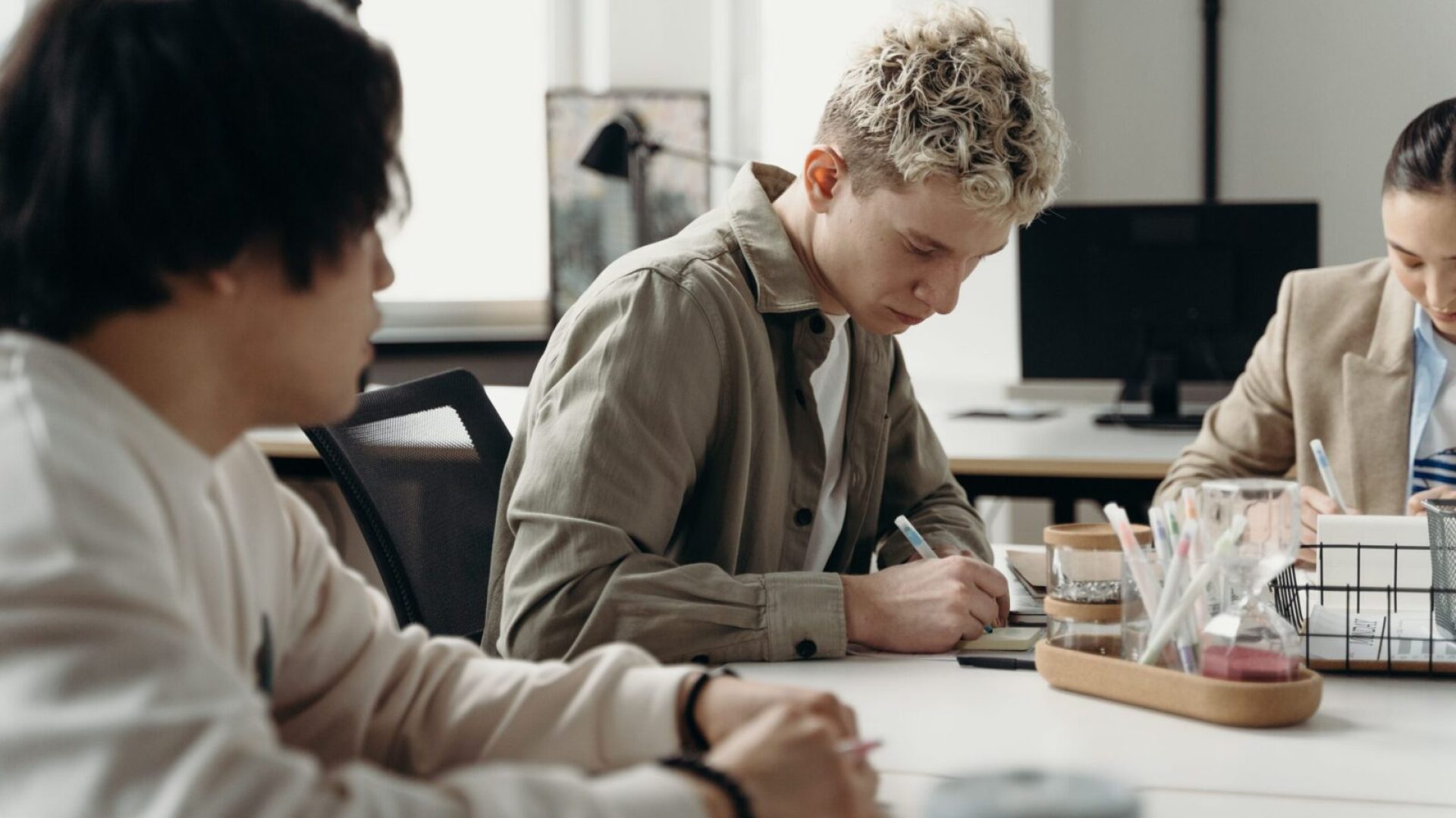 A diverse group of young professionals brainstorming in a contemporary office environment.