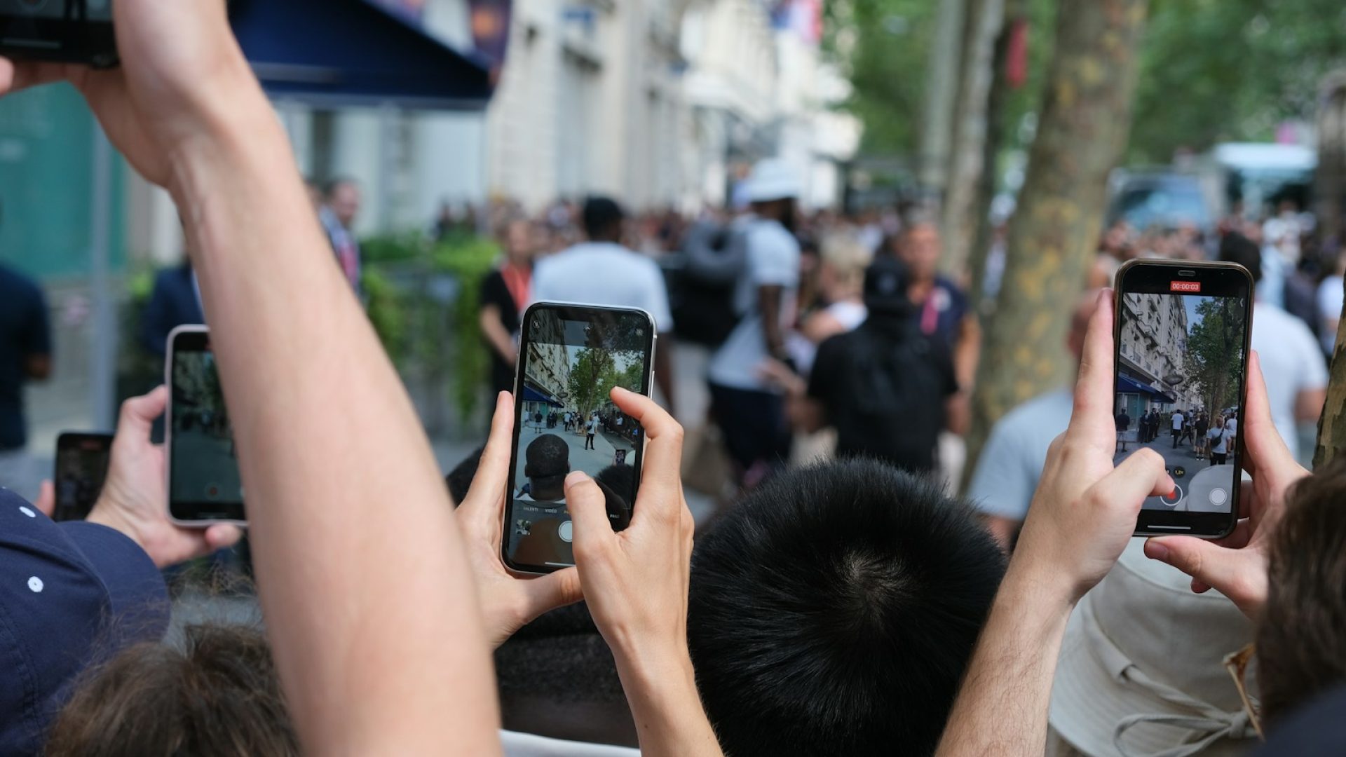 A group of people holding up their cell phones